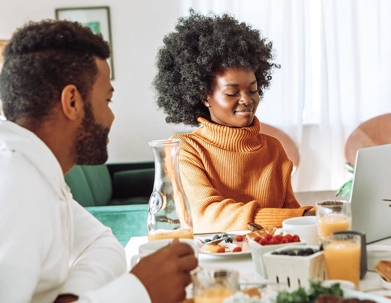 A man and woman looking at a laptop